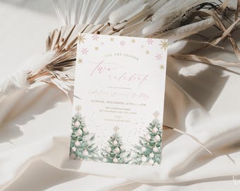 May include: A festive invitation with the text "'Tis the Season Two Celebrate". The invitation features watercolor Christmas trees with ornaments and gold star toppers. Pink and gold snowflakes and text accents complete the design.