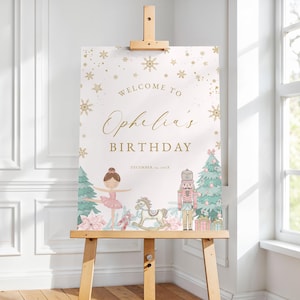 May include: A decorative sign on a wooden easel with the text "Welcome to Ophelia's Birthday" in gold script. The sign features illustrations of a ballerina, a nutcracker, and Christmas trees, with snowflakes and stars.