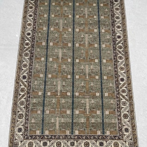 May include: Rectangular area rug with a central field of muted green, featuring vertical blue stripes and repeating geometric patterns in brown and white. The rug has a detailed border with floral and geometric motifs.