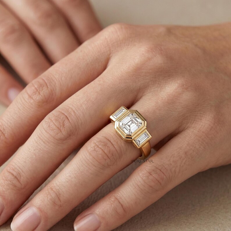 Three stone diamond engagement ring featuring Asscher center stone and baguette side diamonds.