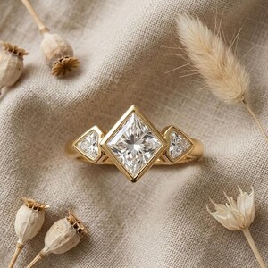 2 carat princess cut lab grown diamond three stone engagement ring with bezel setting and shield side diamonds.
