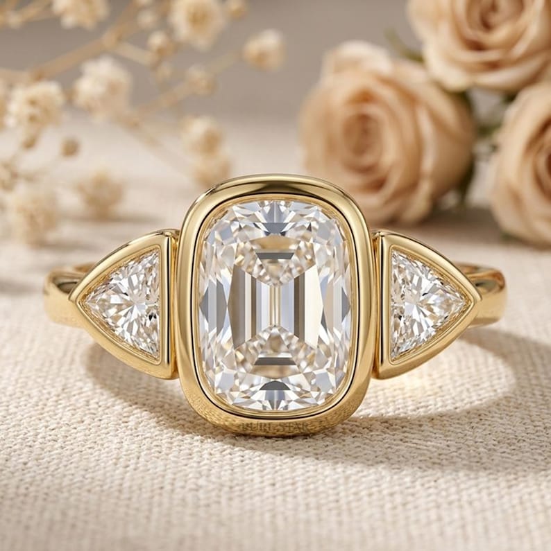 2 carat elongated cushion cut lab grown diamond bezel set trilogy engagement ring with trillion side stones in solid gold