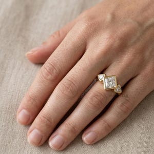 Princess cut diamond wedding ring featuring lab grown center stone and unique side shield diamonds.