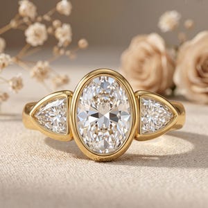 Oval diamond bezel engagement ring in solid 14K yellow gold with sparkling side stones.
