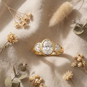 Luxury oval cut engagement ring with half moon diamond accents in white gold setting.