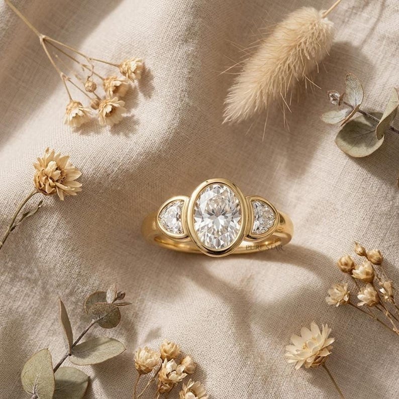 Luxury oval cut engagement ring with half moon diamond accents in white gold setting.