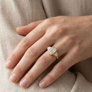 bezel set cushion diamond engagement ring featuring trillion side diamonds and polished gold band