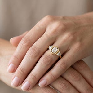 Unique lab grown diamond engagement ring with hexagon center stone and gold wedding band.