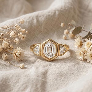 2 carat hexagon lab grown diamond engagement ring with trillion side stones in full bezel gold setting.