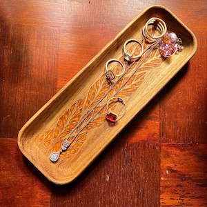 wooden catch all tray with engraved resin in base for keeping jewellery such as pendant chain, rings , precious stones