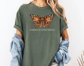 May include: A green t-shirt with a brown butterfly graphic and the text "Embrace Your Wings".