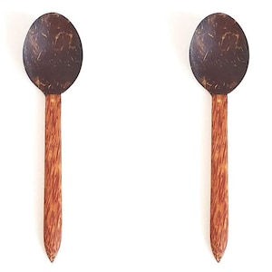 May include: Two brown coconut shell spoons with wooden handles. The spoons are made from natural materials and are perfect for serving desserts, salads, or other dishes.