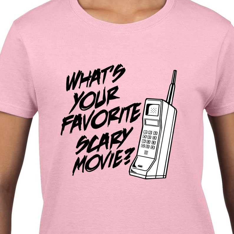 May include: Pink t-shirt with black text that reads "What's your favorite scary movie?" and a black and white illustration of a vintage cell phone.