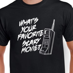May include: Black t-shirt with white text that reads "What's your favorite scary movie?" and a white outline of a vintage cell phone.