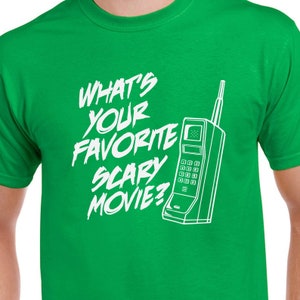 May include: Green t-shirt with white text that reads "What's your favorite scary movie?" and a white outline of a vintage rotary phone.
