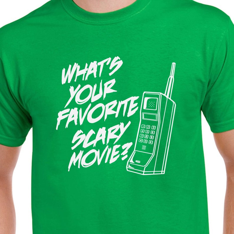 May include: Green t-shirt with white text that reads "What's your favorite scary movie?" and a white outline of a vintage rotary phone.