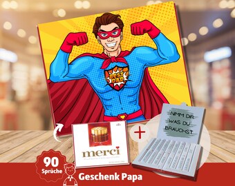 May include: A red and blue superhero illustration with the text "Best Dad" on a yellow background. The image is part of a gift set that includes a box of chocolates and a box of chocolate bars with the text "Nimm dir was du brauchst".