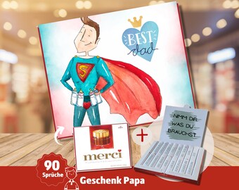 May include: A gift set for a father with a card featuring a cartoon superhero dad, a box of chocolate bars, and a box of assorted pencils. The card says "Best Dad" and the box of pencils says "Nimm dir was du brauchst".