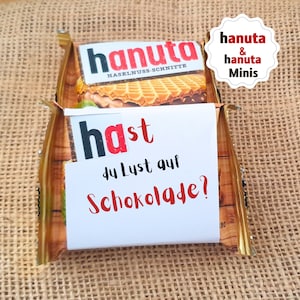 Puede incluir: Un paquete de barritas de chocolate Hanuta con obleas y avellanas con una nota que dice "Hast du Lust auf Schokolade?" que se traduce como "¿Te apetece chocolate?"