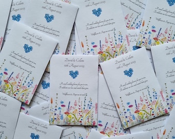 Puede incluir: Sobres de semillas blancos con ilustraciones florales y texto. Cada sobre presenta los nombres "David & Collette" y la fecha "12 de agosto de 2023", junto con un corazón azul y un mensaje.