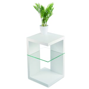 May include: White end table with a glass shelf and a plant in a white pot on the top shelf.