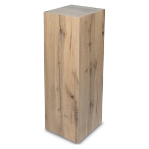 Peut inclure: Un piédestal rectangulaire en bois, haut et de couleur bois clair avec un grain de bois. Le piédestal est en bois et a une surface lisse.