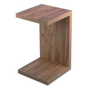 May include: A wooden C-shaped end table with a brown wood grain finish.