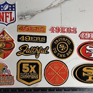 Könnte beinhalten: Eine Sammlung von zwölf bestickten San Francisco 49ers Aufnähern in verschiedenen Formen und Größen. Die Aufnäher zeigen Teamlogos, Schriftzüge wie 49ers, Faithful to the Bay und 5x Super Bowl Champions sowie ein NFL-Logo in Rot, Gold, Schwarz und Weiß.