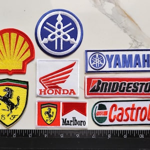 Può includere: Una collezione di toppe ricamate con loghi di marchi popolari. Include Shell, Yamaha, Honda, Ferrari, Marlboro, Bridgestone e Castrol. Le toppe sono di varie forme e dimensioni, con colori vivaci e cuciture dettagliate.