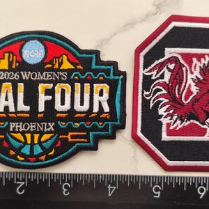 May include: Two embroidered patches. One is a black, turquoise, red, and yellow patch with "2026 WOMEN'S FINAL FOUR PHOENIX" text. The other is a black, red, and white patch with a rooster logo.