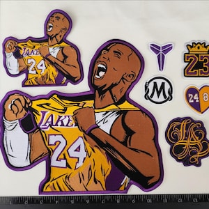 Könnte beinhalten: Eine Sammlung von aufgestickten Aufnähern. Sie zeigen einen Basketballspieler in einem gelb-violetten Trikot mit der Nummer 24. Weitere Aufnäher zeigen ein lila Logo, eine Krone mit der Nummer 23, ein Herz mit den Zahlen 24 und 8 sowie ein LA-Logo.