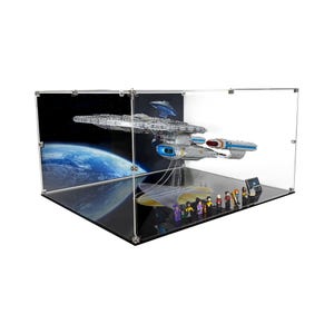 May include: A clear display case showcasing a model of a spaceship, with a detailed design and blue and silver accents. The case includes miniature figures and a backdrop of space and a planet.
