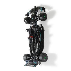 Puede incluir: Un modelo LEGO negro y verde de un coche de carreras de Fórmula 1. El coche tiene el logotipo de Petronas en el lateral y las palabras "PETRONAS" y "SINOPEC" en la parte delantera y trasera. El coche está sobre un fondo blanco.