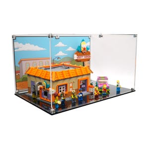 Peut inclure: Un ensemble Lego Krusty Burger exposé dans un boîtier en acrylique transparent. Le bâtiment a un toit orange et une enseigne qui dit "Krusty Burger". Plusieurs figurines Lego sont devant le bâtiment, et une voiture rose est garée à proximité.