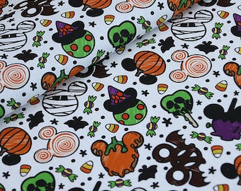 May include: White fabric with a repeating pattern of Halloween-themed Mickey Mouse heads. The pattern includes candy corn, pumpkins, ghosts, and Mickey Mouse ears with swirls.