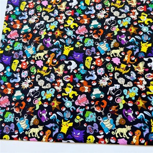 May include: A black fabric with a repeating pattern of colorful cartoon characters. The characters are from the Pokemon franchise and include Pikachu, Charmander, Squirtle, Bulbasaur, and many more.