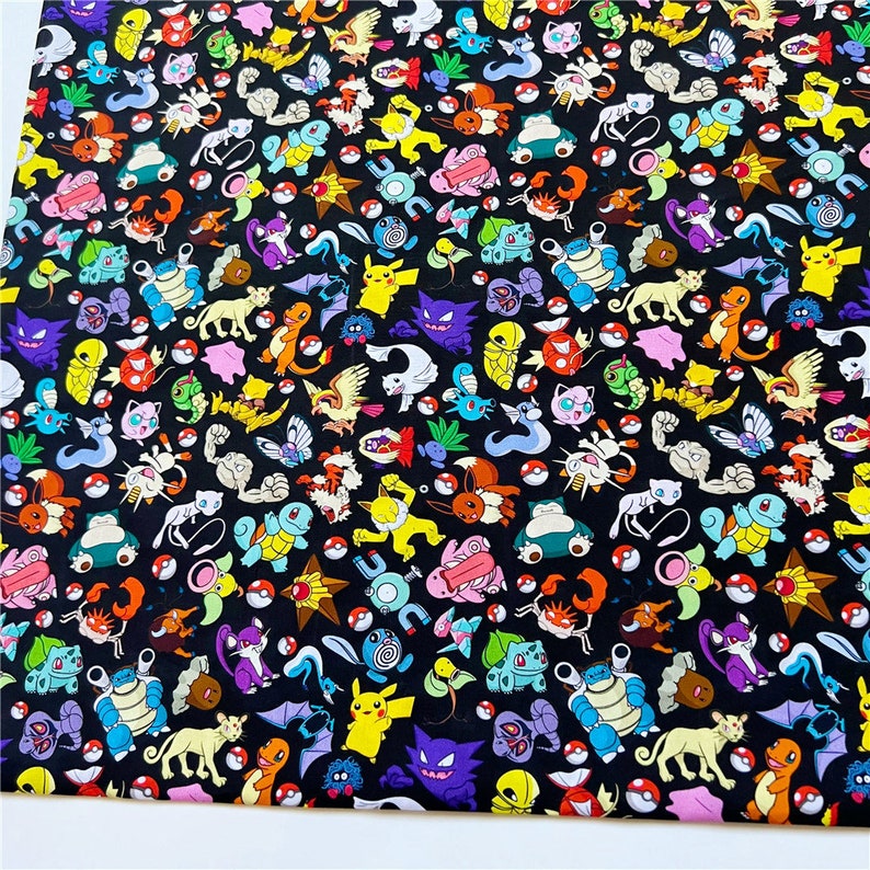 May include: A black fabric with a repeating pattern of colorful cartoon characters. The characters are from the Pokemon franchise and include Pikachu, Charmander, Squirtle, Bulbasaur, and many more.