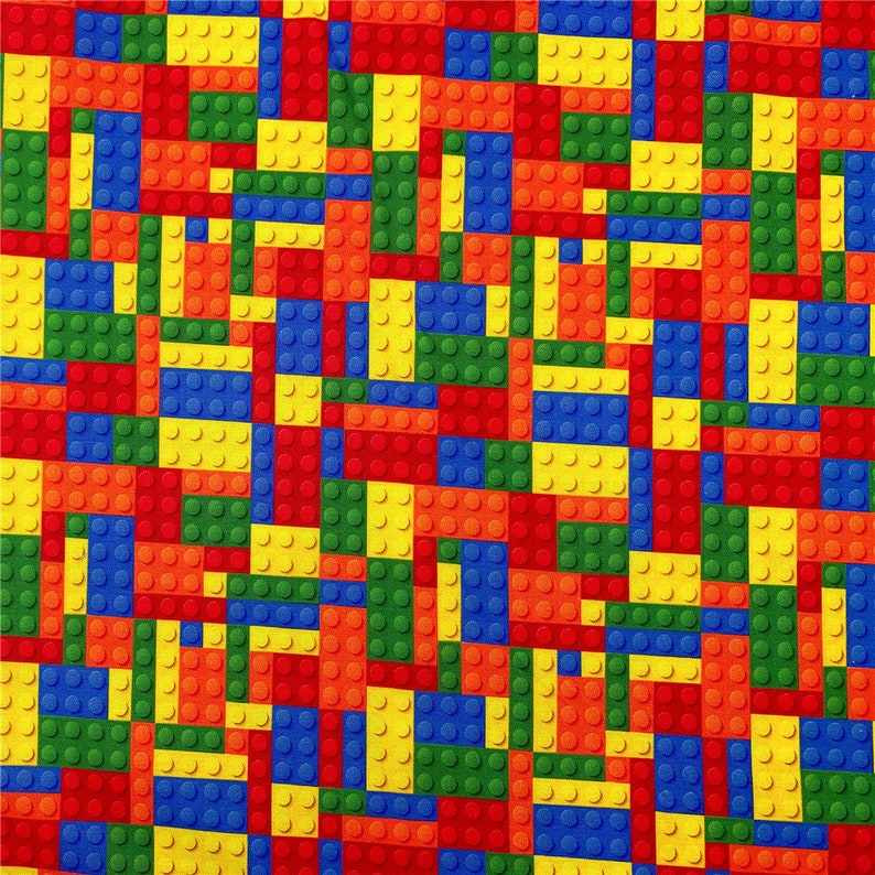 K&ouml;nnte beinhalten: Ein farbenfroher Stoff mit einem sich wiederholenden Muster aus roten, gelben, blauen und gr&uuml;nen Lego-Steinen.