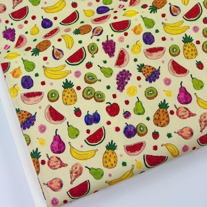 Könnte beinhalten: Ein Stoff mit einem sich wiederholenden Muster aus verschiedenen Früchten, darunter Ananas, Wassermelonen, Bananen, Trauben, Birnen und Kiwis. Die Früchte sind in leuchtenden Farben auf einem hellgelben Hintergrund dargestellt. Kleine rosa Blüten sind im Design verstreut.