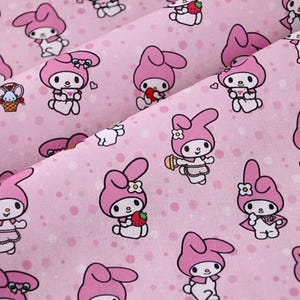 May include: Pink fabric with a repeating pattern of a cartoon rabbit wearing a pink dress and a bow. The background is a light pink with white polka dots.