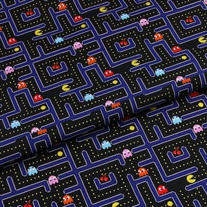 May include: Black fabric featuring a repeating Pac-Man maze design. The maze is outlined in blue, with yellow dots and colourful Pac-Man characters. The design also includes cherries and Pac-Man figures in various colours.
