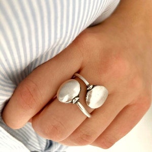 Peut inclure: Une bague en argent avec deux pièces rondes, légèrement texturées, reliées.