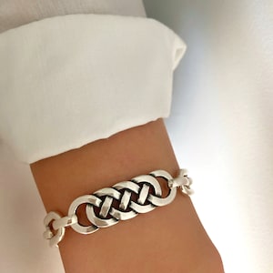 Peut inclure: Un bracelet en argent avec un motif tressé. Le bracelet est composé de maillons épais et robustes.