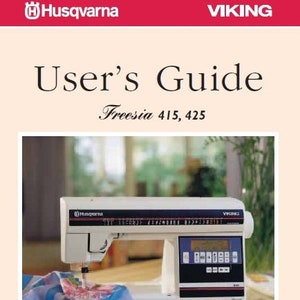 May include: A white sewing machine with a digital display and a needle threading a piece of blue and pink fabric. The machine is labeled "Husqvarna" and "Viking". The text "User's Guide Freesia 415, 425" is above the image. The text "Keeping the World Sewing" is below the image.