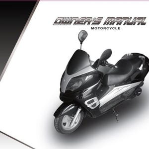 May include: A black and silver motorcycle with a windshield and side mirrors. The text "OWNER'S MANUAL MOTORCYCLE" is at the top of the image. The motorcycle is on a white background with a gray and black gradient in the upper left corner.
