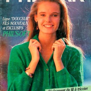Könnte beinhalten: Eine Frau trägt einen grünen Pullover mit dem Text "PHIL'S SOFT" auf der Vorderseite. Der Text "Ligne "DOUCEUR" FILS NOUVEAUX et EXCLUSIFS PHIL'S SOFT" ist ebenfalls auf dem Bild zu sehen.