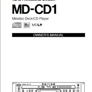 Könnte beinhalten: Schwarz-Weiß-Bild eines Tascam MD-CD1 Minidisc Deck/CD-Players. Die Texte "TASCAM" und "MD-CD1" sind deutlich sichtbar. Das Bild enthält auch die Wörter "Minidisc Deck/CD Player" und "Owner's Manual".