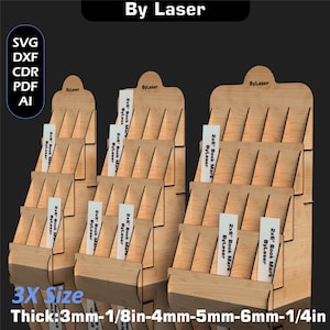 Puede incluir: Expositores de madera con m&uacute;ltiples estantes, cada uno con varios marcadores de libros de 2x6". Los expositores est&aacute;n etiquetados como "By Laser" y est&aacute;n disponibles en varios grosores, incluyendo 3mm, 4mm, 5mm y 6mm. El texto "3X Size" tambi&eacute;n es visible.