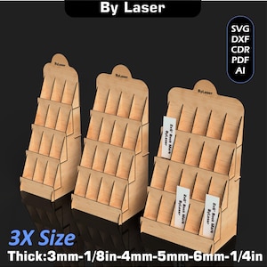 Puede incluir: Tres expositores de madera con m&uacute;ltiples estantes, etiquetados "By Laser" en la parte superior. Los expositores est&aacute;n dise&ntilde;ados para contener art&iacute;culos como marcap&aacute;ginas. El texto "3X Size" y las medidas de grosor tambi&eacute;n son visibles.