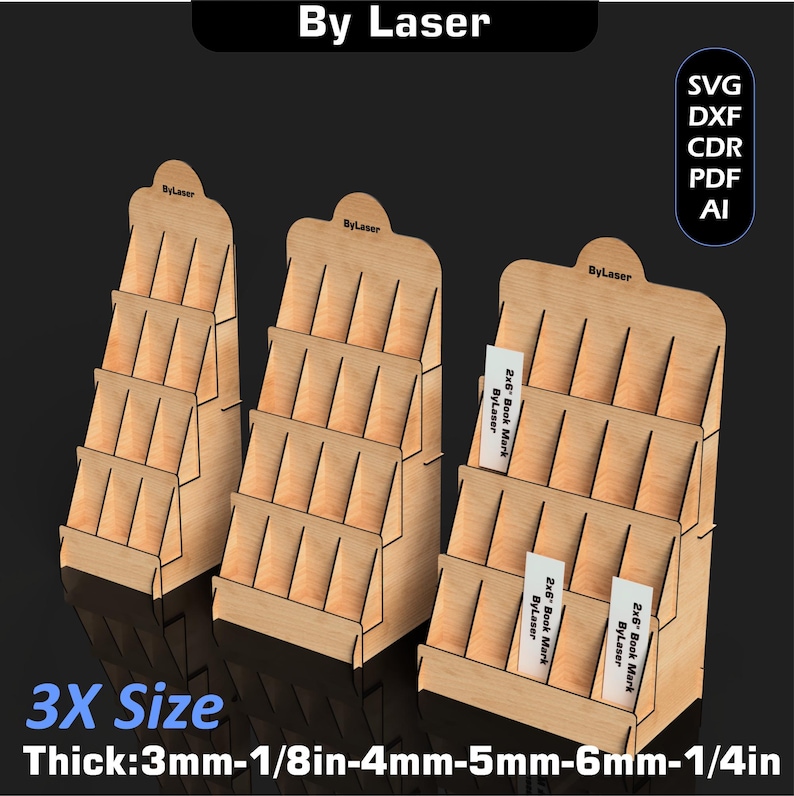 Puede incluir: Tres expositores de madera con m&uacute;ltiples estantes, etiquetados "By Laser" en la parte superior. Los expositores est&aacute;n dise&ntilde;ados para contener art&iacute;culos como marcap&aacute;ginas. El texto "3X Size" y las medidas de grosor tambi&eacute;n son visibles.